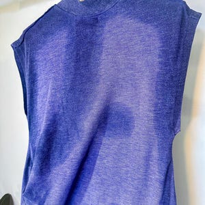 May include: A sleeveless, blue and white ombre, tie-dye shirt with a mock neck.