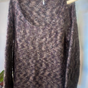 May include: A brown and beige fuzzy knit sweater with a scoop neck and long sleeves.
