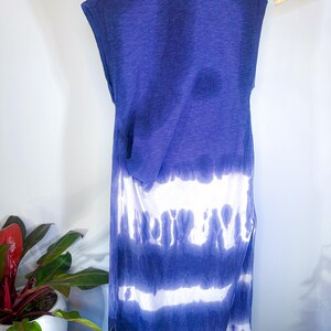 May include: A long, sleeveless, tie-dye dress in shades of blue and white. The dress has a relaxed fit and a slightly gathered waist.