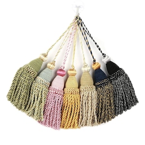 May include: A collection of seven decorative tassels in various colors, including green, pink, gold, and black. Each tassel features a decorative top and a long, fringed bottom, perfect for adding a touch of elegance to curtains or other home decor items.