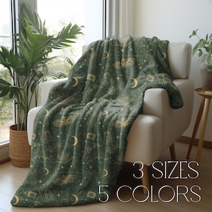 May include: A soft green fleece throw blanket with a gold and green pattern of moons, stars, and other celestial imagery. The text "3 SIZES 5 COLORS" is printed on the bottom right corner of the image.