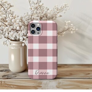May include: A pink and white checkered phone case with the name "Dianne" written in cursive on the bottom.