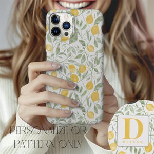 May include: A white phone case with a lemon and leaf pattern. The case has a clear camera lens cutout. The case is personalized with the letter "D" and the name "Dianne".