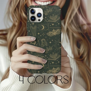 May include: A green phone case with a gold design featuring a book, a crown, a mask, and stars. The case is for an iPhone.
