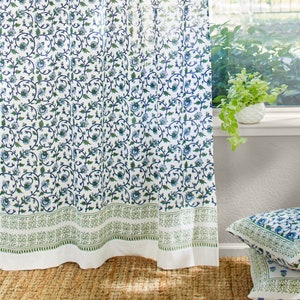 May include: White sheer curtains with a blue and green floral pattern. The curtains have a green border at the bottom.