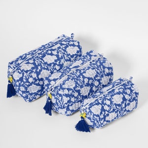 May include: Three rectangular quilted pouches in varying sizes, featuring a blue and white floral pattern. Each pouch has a top zipper closure with a blue tassel pull and a small yellow accent bead attached to the zipper slider.