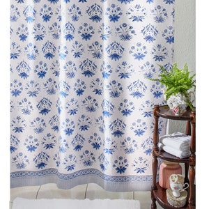 May include: White shower curtain with a blue floral pattern. The pattern features small blue flowers and leaves on a white background. The curtain has a blue and white border.