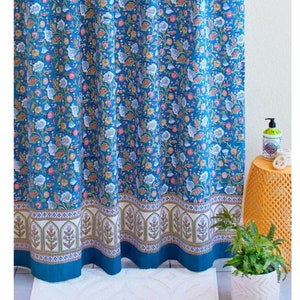 May include: A blue shower curtain with a floral pattern. The curtain has a white border with a repeating design of arches and flowers.