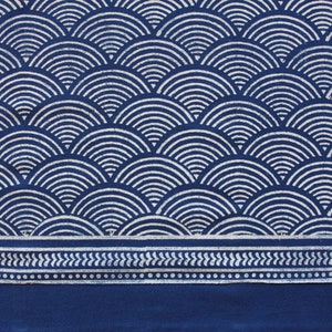 May include: Indigo blue fabric with a white geometric pattern of overlapping semi-circles. The fabric has a white border with a repeating pattern of small white dots and leaves.