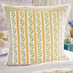 May include: A white pillowcase with a green and orange floral pattern. The pattern features repeating vertical stripes of green leaves and orange vines.