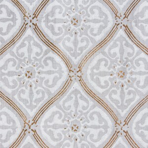 May include: White fabric with a repeating pattern of gold-colored diamond shapes and floral designs.