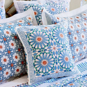 May include: A set of decorative throw pillows with a blue and white geometric pattern. The pillows feature a repeating design of stylized flowers and intricate details.