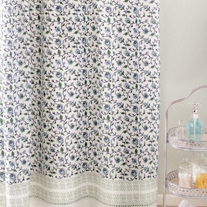 May include: White shower curtain with a blue and green floral pattern. The pattern features a repeating design of stylized flowers and leaves.
