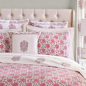 K&ouml;nnte beinhalten: Ein wei&szlig;es Bett mit einem rosafarbenen, floral gemusterten Bettbezug und passenden Kissenbez&uuml;gen. Das Bett hat ein gestepptes Kopfteil und ist mit zus&auml;tzlichen Dekokissen ausgestattet.