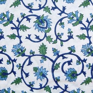 K&ouml;nnte beinhalten: Ein wei&szlig;er Stoff mit einem blauen und gr&uuml;nen Blumenmuster. Das Muster zeigt stilisierte Blumen und Bl&auml;tter.