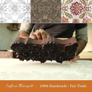 May include: A close-up of a wooden printing block with a floral design. The block is being used to print a fabric with a similar design. The text "Saffron Marigold - 100% Handmade - Fair Trade" is visible at the bottom of the image.