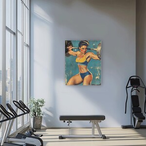 May include: A vintage-style poster featuring a woman lifting weights. The woman is wearing a blue and yellow swimsuit and is posed in a dynamic lifting position. The poster has a faded, distressed look, giving it a retro feel.