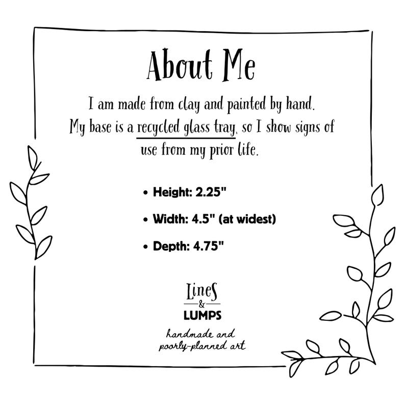 May include: A black and white image with the text "About Me" and product dimensions. The text states the item is made from clay, hand-painted, and uses a recycled glass tray base. Dimensions are: Height 5.7 cm, Width 11.4 cm, Depth 12.1 cm.