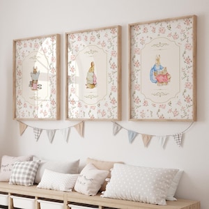 May include: A white bench with a light wood frame and eight storage bins. The bench is decorated with a garland of flags and three framed prints featuring illustrations of Peter Rabbit.