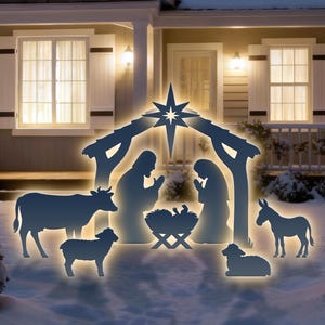 May include: A glowing outdoor Christmas nativity scene. The silhouette figures include Mary, Joseph, baby Jesus in a manger, a cow, a donkey, and a sheep. The scene is set in front of a house with snow on the ground.