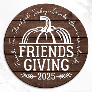 May include: A circular wooden sign with a dark brown finish and white lettering. The sign reads "Friends Giving 2025" with a pumpkin graphic. The words "Fun, Thankful, Turkey, Drinks, Games, Laughs, Pie" are written around the pumpkin.