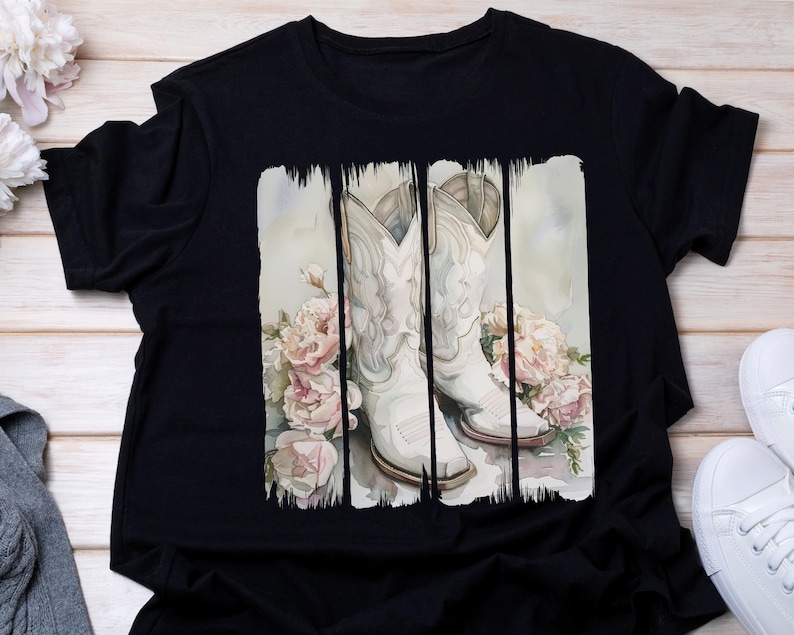 Pode incluir: Camiseta preta com um design de aquarela de botas de cowboy brancas e flores.