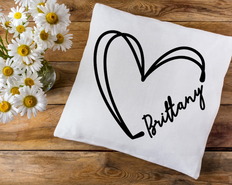 May include: White pillow with a black hand-drawn heart and the name "Brittany" written in cursive.