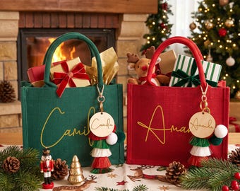May include: A green jute tote bag with the name Camila in gold script and a red jute tote bag with the name Amanda in gold script. Each bag features a round wooden tag with the corresponding name and a multi-colored tassel keychain attached.