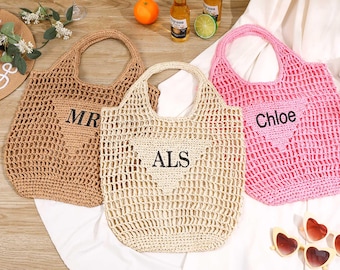 May include: Three open-weave tote bags in tan, cream, and pink. The tan bag has "MR" stitched on it, the cream bag has "ALS", and the pink bag has "Chloe". The bags have matching handles and are made of a woven material.