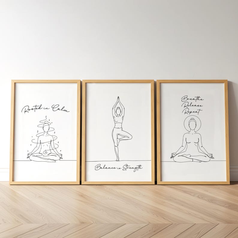 May include: Three framed art prints with line drawings of yoga poses. The prints have a white background and a natural wood frame. Text includes "Rooted in Calm", "Balance is Strength", and "Breathe Release Repeat".