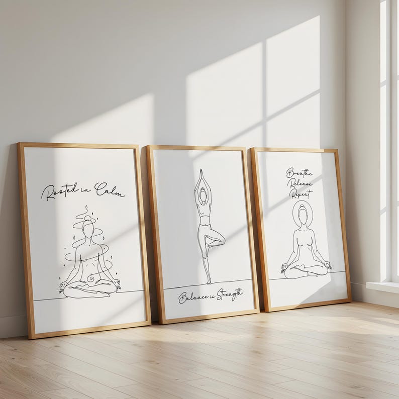 May include: Three framed art prints with line drawings of yoga poses. The prints have a white background and wooden frames. Text on the prints reads "Rooted in Calm", "Balance is Strength", and "Breathe Release Repeat".