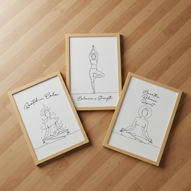 May include: Three framed art prints with line drawings of yoga poses. The prints have a light wood frame and white background. Text on the prints reads "Rooted in Calm", "Balance is Strength", and "Breathe Release Repeat".