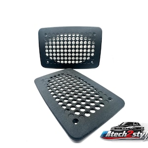May include: Two black rectangular car vent covers with a grid of circular holes. One cover is positioned above the other. The image includes a logo with a car and the text "Atech2style lab".