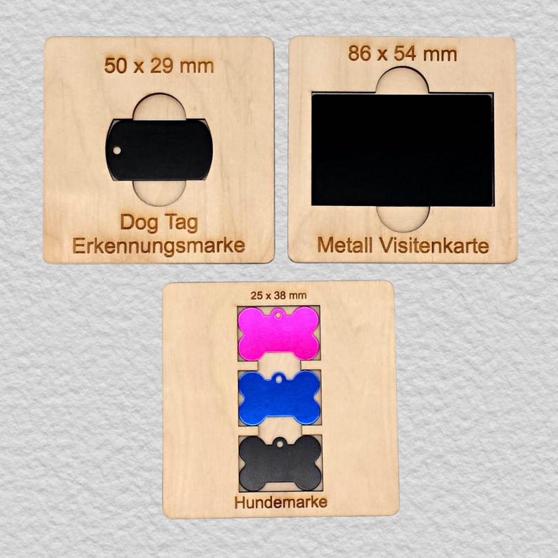 May include: Three light-colored wooden templates featuring cutouts for metal items. The top left shows a 50 x 29 mm dog tag, the top right a 86 x 54 mm metal business card, and the bottom a 25 x 38 mm pink, blue, and black bone-shaped tag.