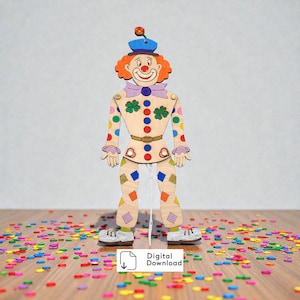 Könnte beinhalten: Eine hölzerne Clown-Marionette mit orangefarbenen Haaren, einem blauen Hut mit kleiner Blume und einem hellen Körper, der mit bunten Punkten und Rauten verziert ist. Die Figur hat eine violette Fliege, eine rote Nase und eine weiße Schnur.