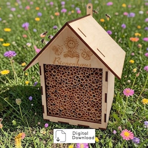 May include: A light-colored wooden bee house with a gabled roof, featuring a laser-engraved sunflower and two bees above the text Bienenhaus. The front panel is filled with numerous small, hollow bamboo tubes for nesting, creating a structured habitat.