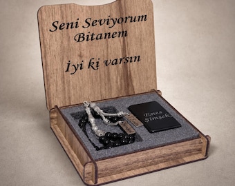 May include: A wooden box with an open lid featuring the engraved text "Seni Seviyorum Bitanem" and "Iyi ki varsın". Inside, a set of black prayer beads with silver accents and a black rectangular metal plate engraved with "Enes Şimşek".