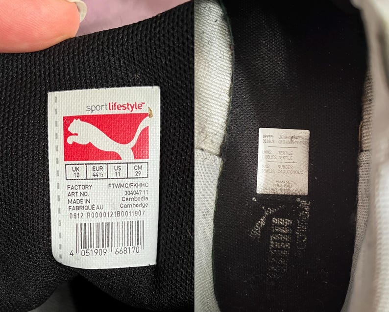 Pu&ograve; includere: Una scarpa Puma bianca e nera con un'etichetta nera sul lato. L'etichetta presenta il logo Puma e il testo "sportlifestyle". L'etichetta include anche informazioni sulle dimensioni in UK, EUR, US e CM. L'etichetta include anche la fabbrica, il numero d'articolo e il paese d'origine. La scarpa ha una suola in gomma nera.