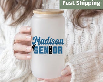 May include: White frosted tumbler with a bamboo lid and a blue and black design that says "Madison Senior 2025".