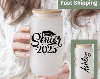 May include: White frosted tumbler with a black graduation cap and the text "Senior 2025" on the front. The tumbler has a bamboo lid and a straw. The back of the tumbler is blank and can be personalized.