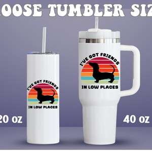 May include: White tumblers with a dachshund graphic and the text "I've Got Friends in Low Places." One tumbler is 20 oz, the other is 40 oz. Both have a straw. The tumblers are cylindrical and have a handle.