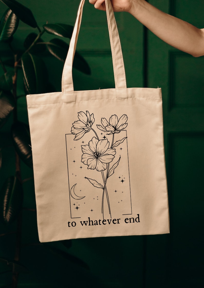 May include: A white canvas tote bag with black line art of flowers and stars. The text "to whatever end" is printed on the bag.