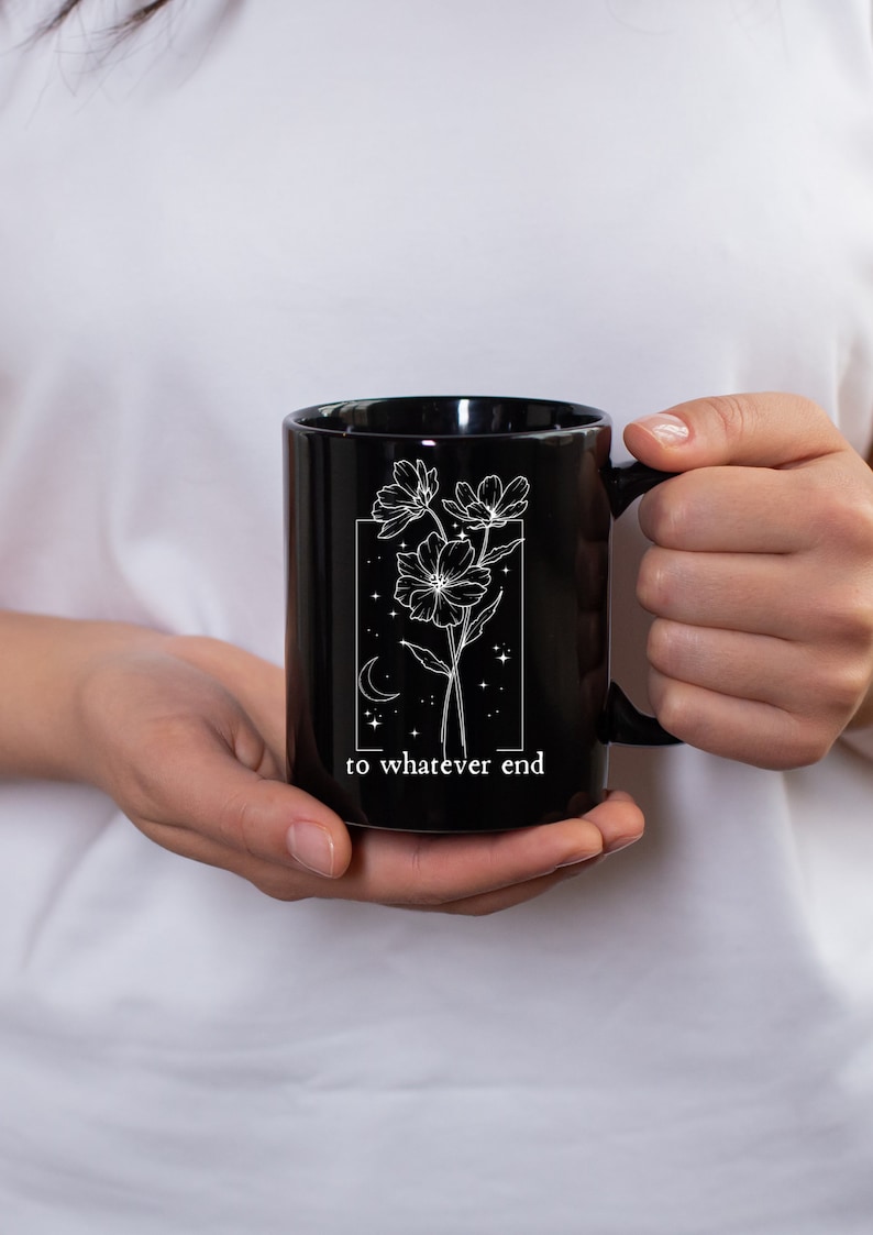 May include: Black ceramic mug with a white floral design and the text "to whatever end".