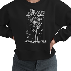 May include: Black sweatshirt with a white graphic of flowers, a crescent moon, and stars inside a rectangle. The text "to whatever end" is below the graphic.
