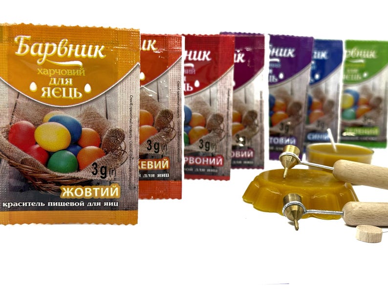 May include: Assortment of food coloring packets for dyeing Easter eggs. The packets are labeled with the colors: yellow, red, brown, blue, green. Each packet contains 3 grams of food coloring. The image also shows a small candle and two wooden sticks with metal tips.