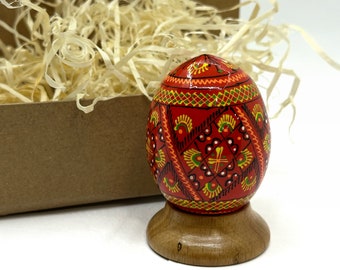 Box with a single Red wooden Easter eggs and a stand, pysanka, Ukrainian souvenir and a gift for Easter.