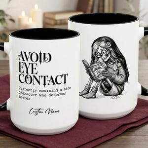 Puede incluir: Taza de cerámica blanca con interior y asa negros. La taza presenta el texto "AVOID EYE CONTACT" y "Currently mourning a side character who deserved better." Un esqueleto leyendo un libro está en el otro lado.