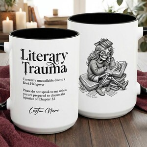 Puede incluir: Dos tazas de cerámica blanca con interiores y asas negras. Una taza presenta el texto "Literary Trauma" y un mensaje humorístico. La otra taza muestra una ilustración detallada en blanco y negro de un esqueleto leyendo libros.
