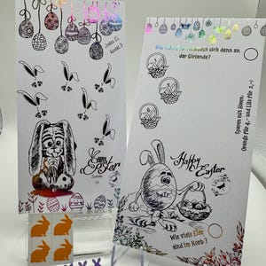 May include: Two Easter-themed activity cards with bunny illustrations and colorful eggs. The cards feature questions about counting eggs and identifying the colors of the eggs. The cards are printed on white cardstock and have a holographic finish.