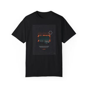 Puede incluir: Camiseta negra con un estampado gráfico de un paisaje oscuro con la palabra "ALONE" en texto naranja.